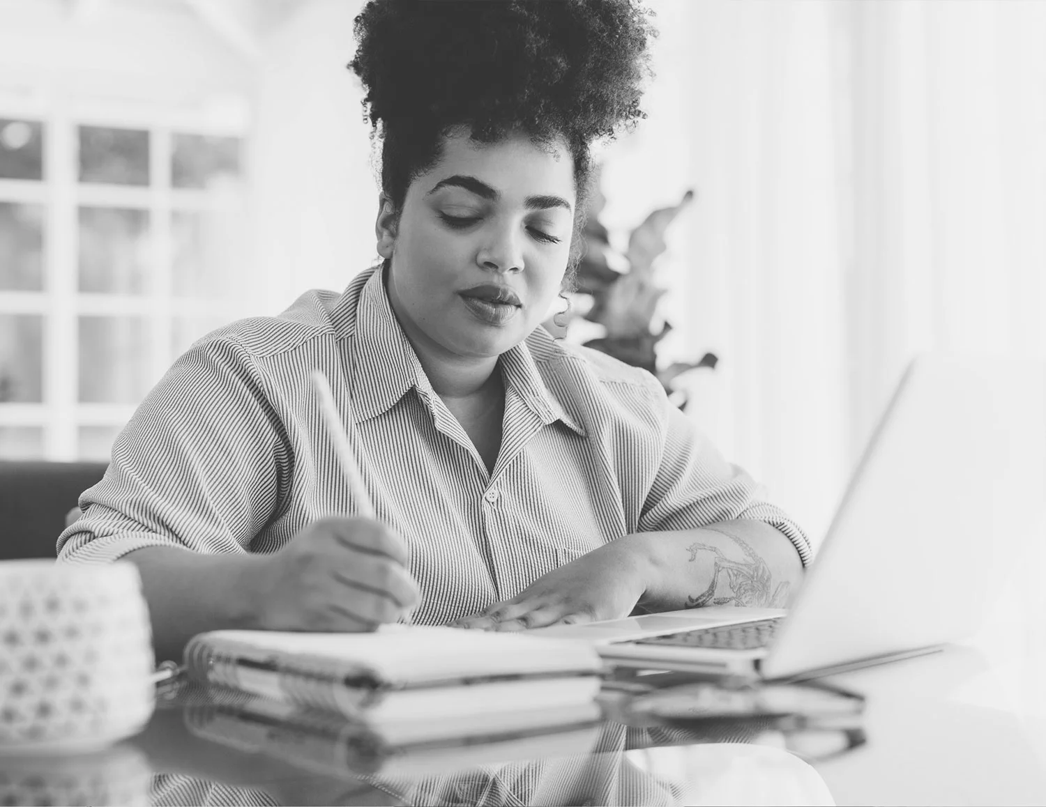 A person takes notes at a laptop