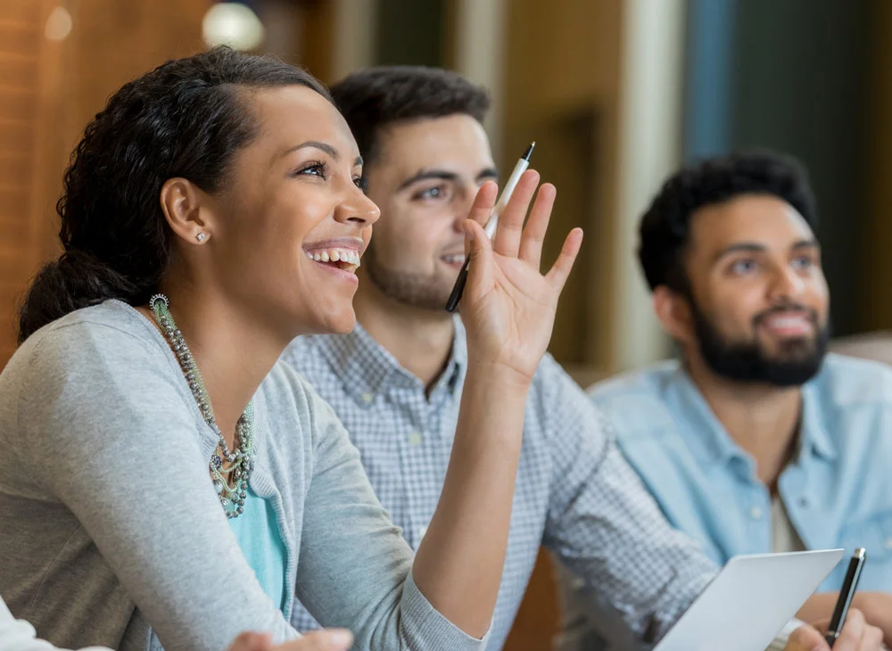 A person raises their hand in a group