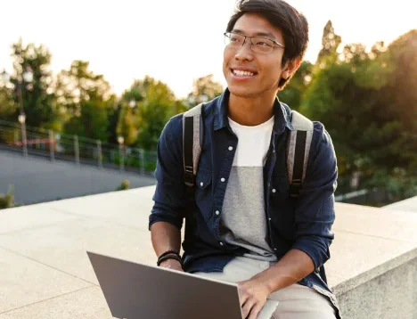 A man on his laptop studying outside